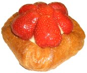 ein Kleingebäckteilchen mit Erdbeeren darauf